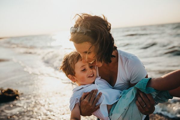 Madre abrazando a su hijo en la playa